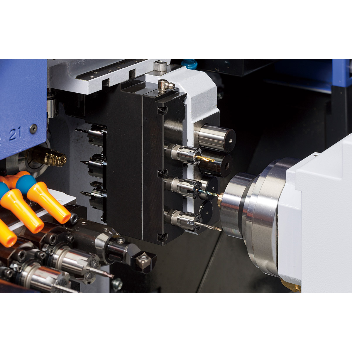 Swiss-type CNC tool block with live tooling and driven spindles engaged on bar stock