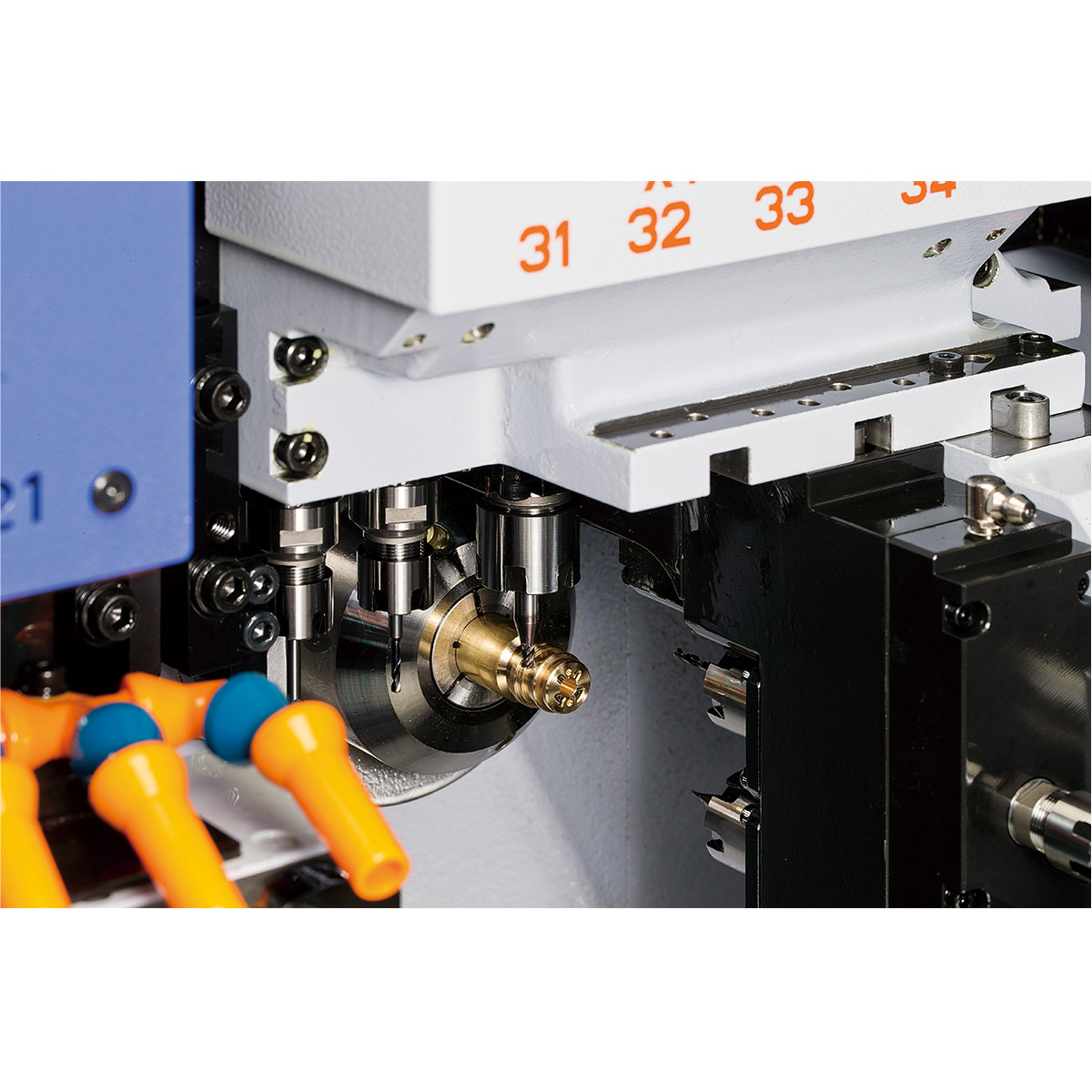 Cross-drilling operation in progress on a brass component at the sub-spindle